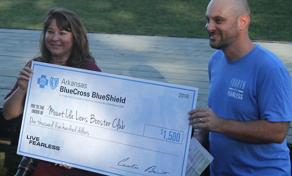 Mount Ida Booster Club president Sherry Ellison (left) accepts a $1500 check from Arkansas Blue Cross and Blue Shield Regional Executive Bryan Dorathy.